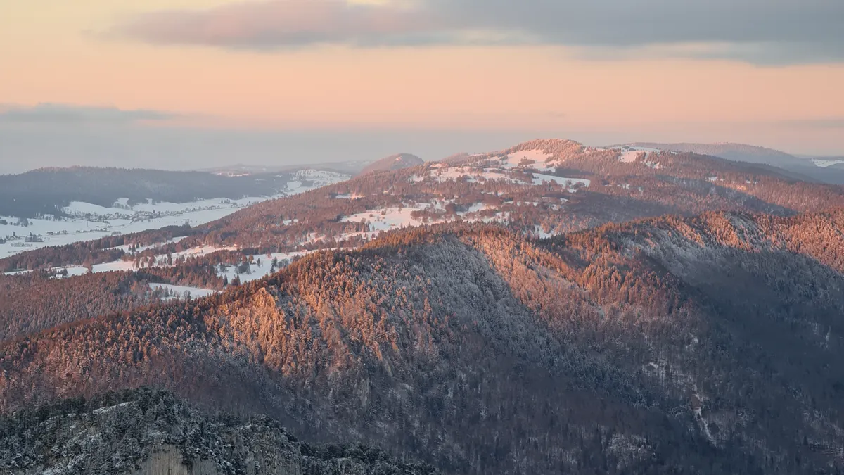 Mountain ridge sunset transitioning from golden hour into blue hour Snowy mountain landscape transitioning between golden hour sunset and blue hour twilight